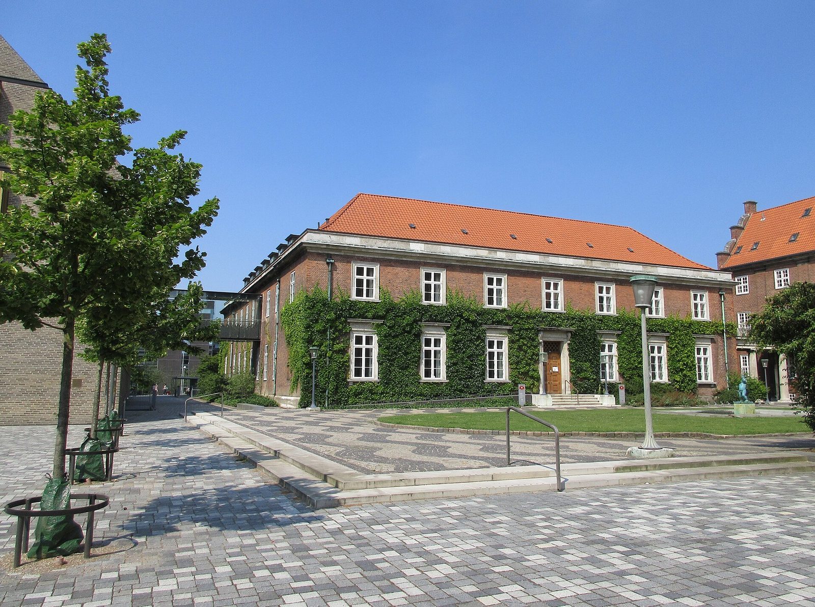 Red brick courthouse with ivy, paved courtyard and entrance steps, Copenhagen