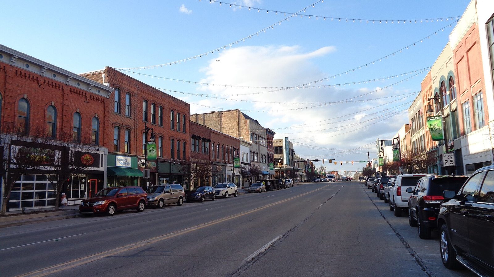 Empty downtown street with brick storefronts and overhead string lights, Port Huron