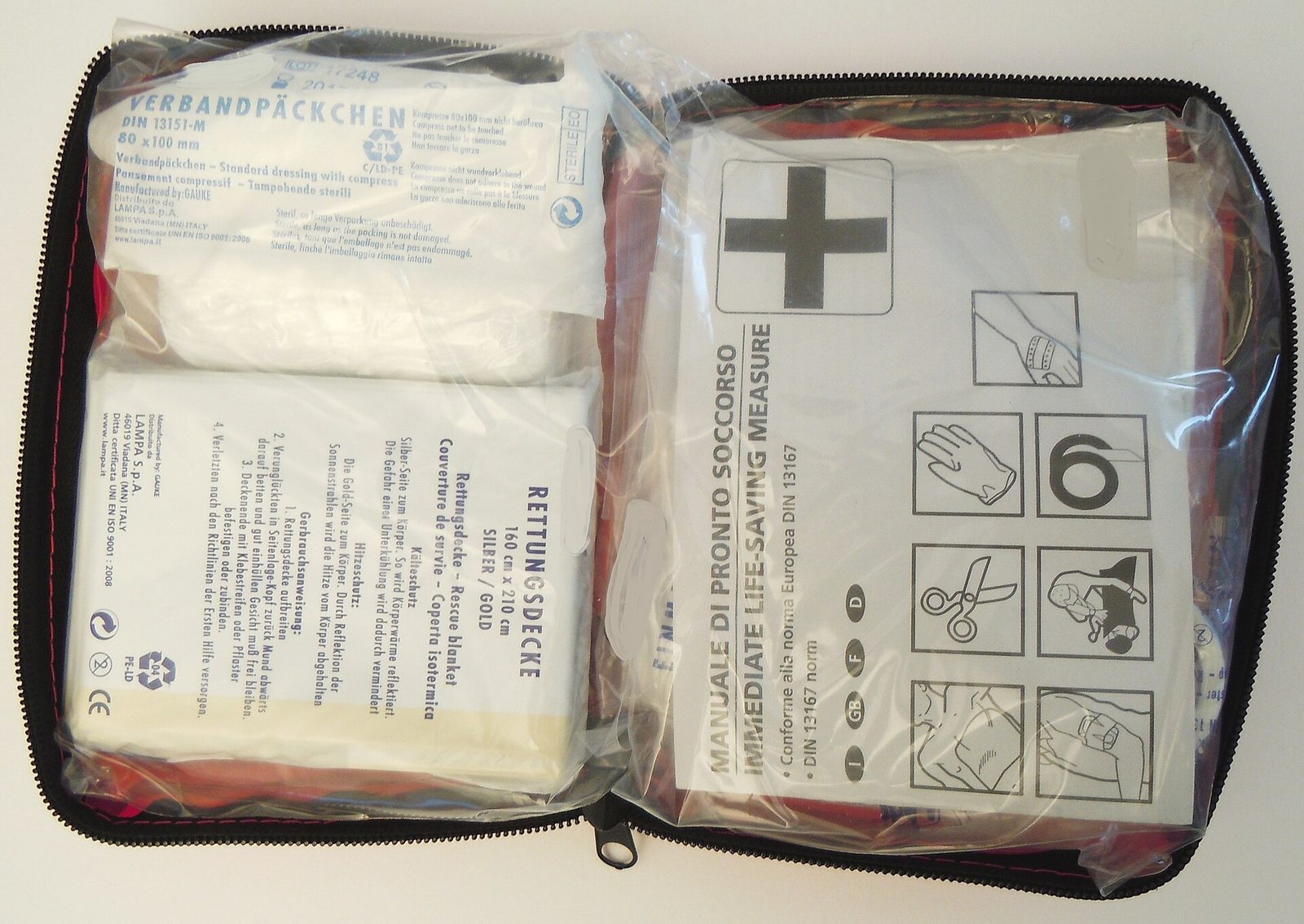 open first-aid bag with dressings, manuals in clear plastic
