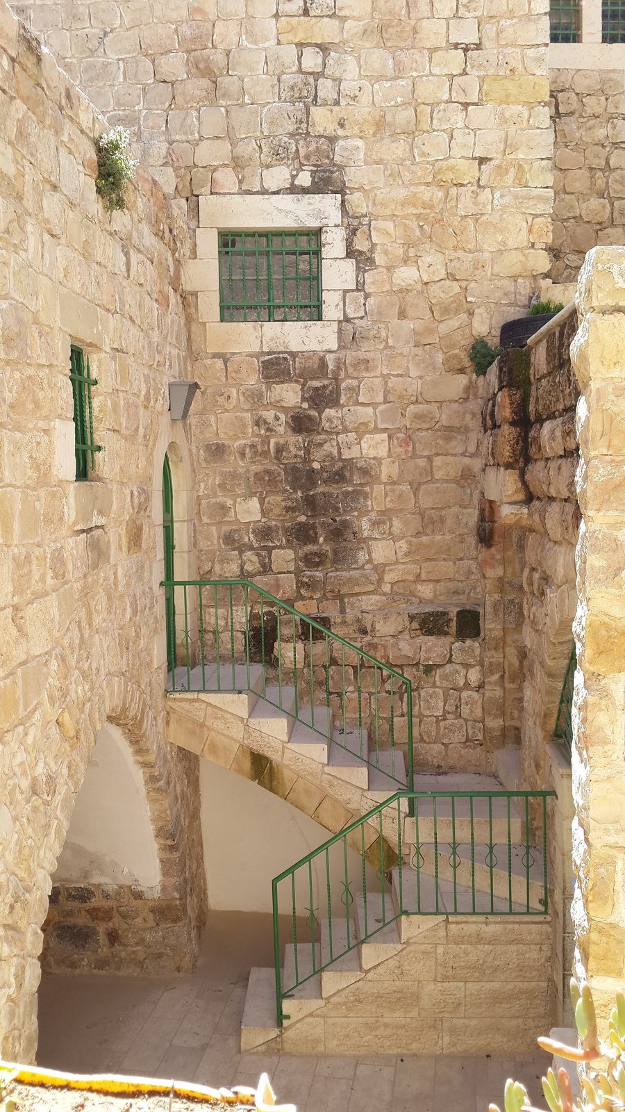 stone stairway and walls, green railings and barred windows, Hebron