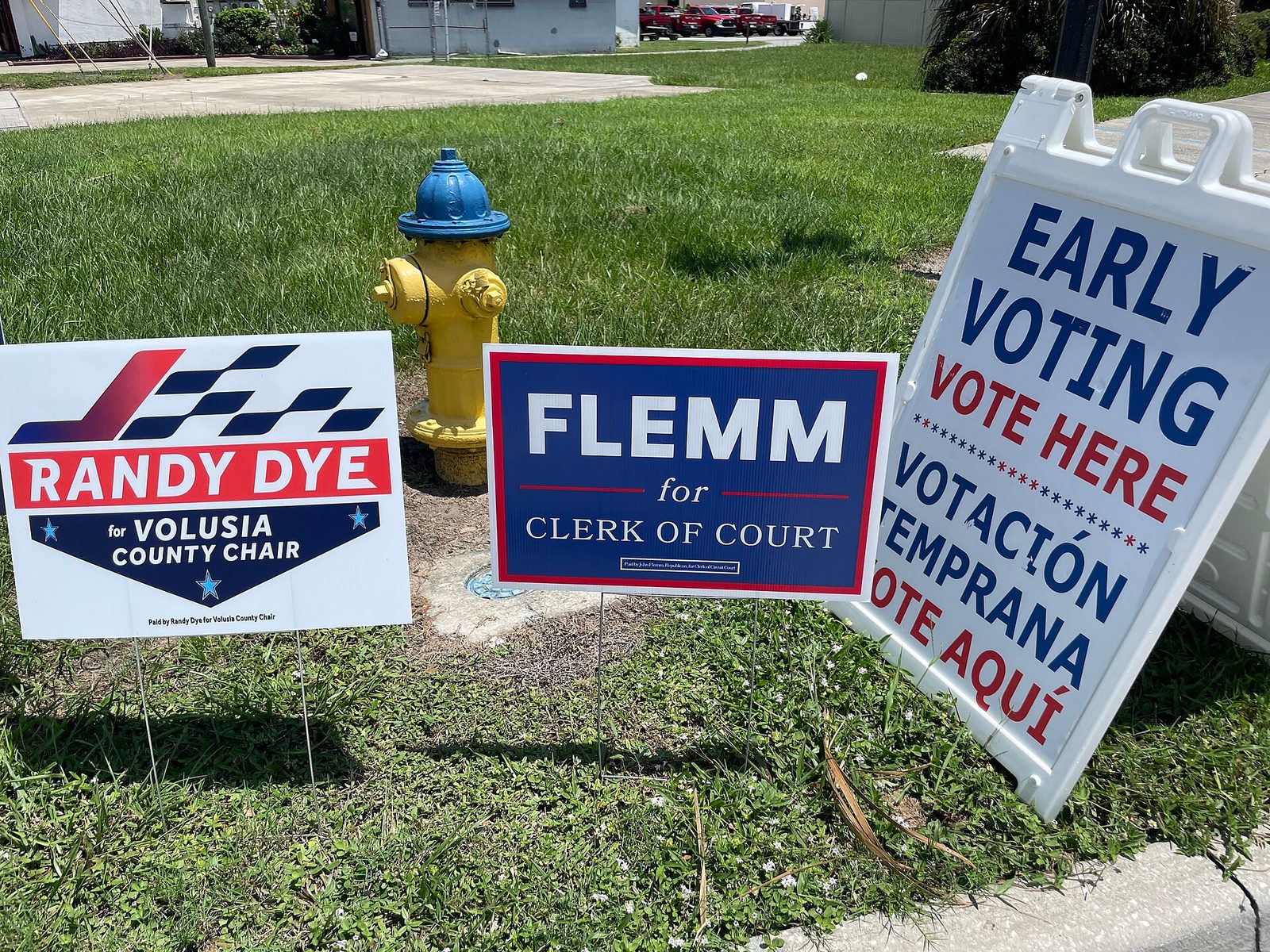 Cluster of campaign signs with an 'EARLY VOTING VOTE HERE' sandwich board