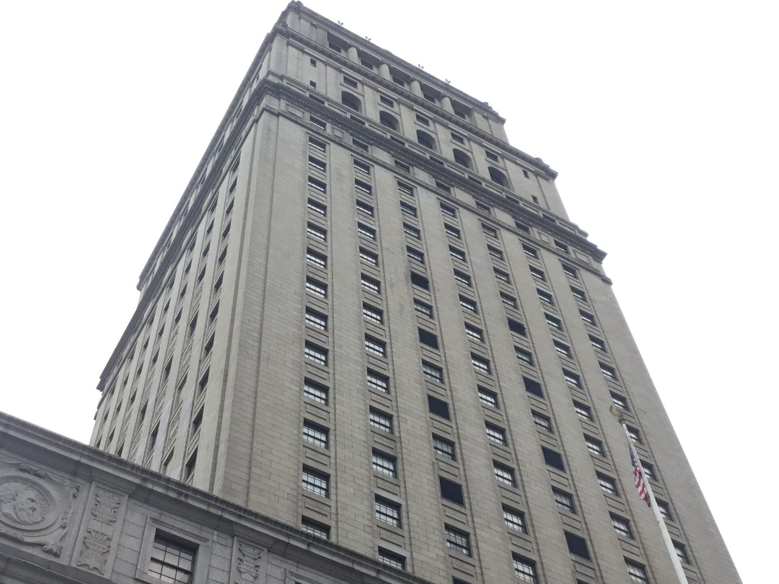 Low-angle side view of tall courthouse tower and facade, New York City