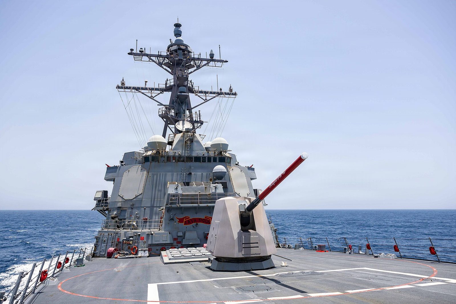 Forward gun and superstructure of a destroyer at sea.
