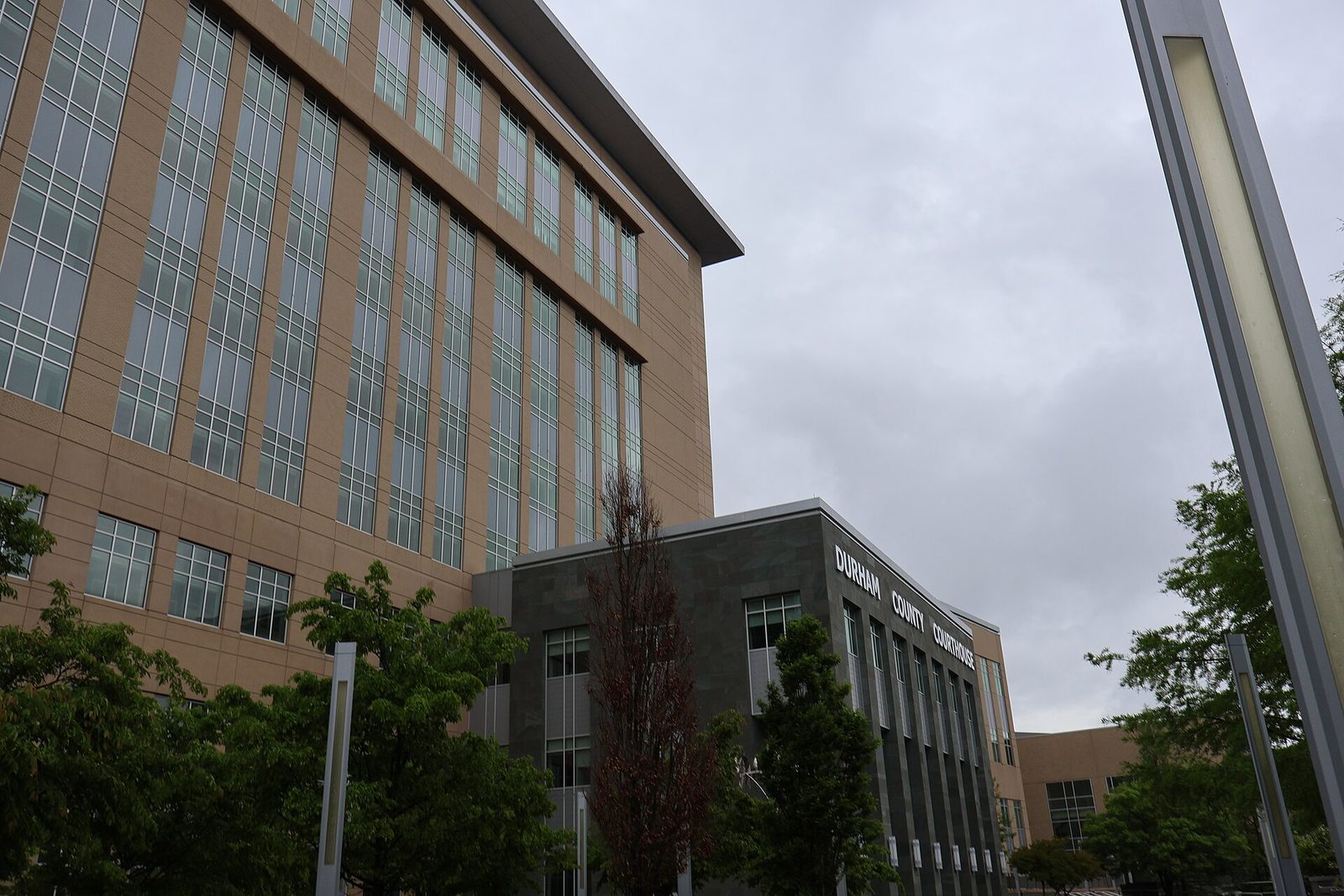 Stone sign reading 'Durham County Justice Center' at courthouse base, Durham County Courthouse