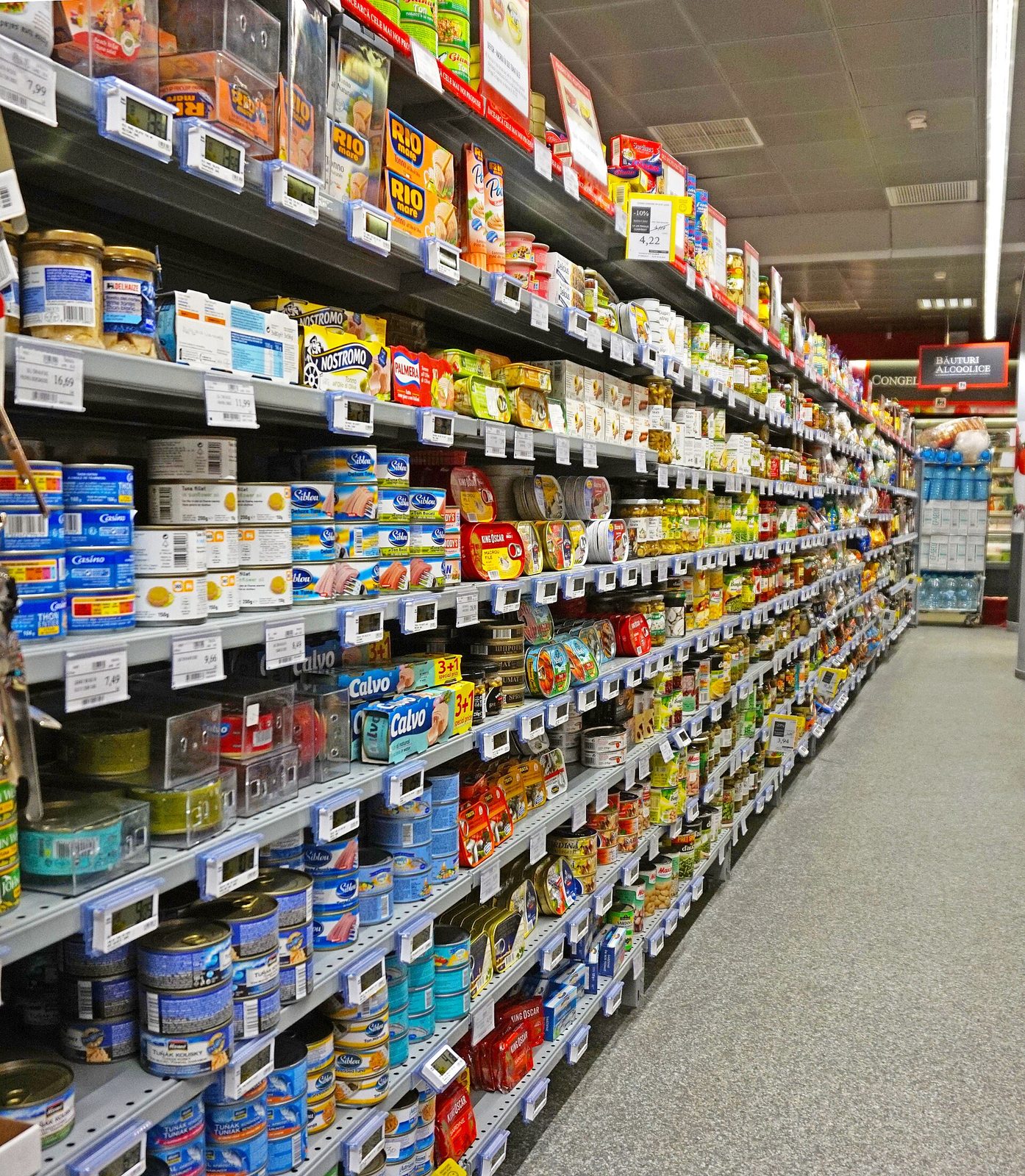 Supermarket aisle fully stocked with tins and canned goods
