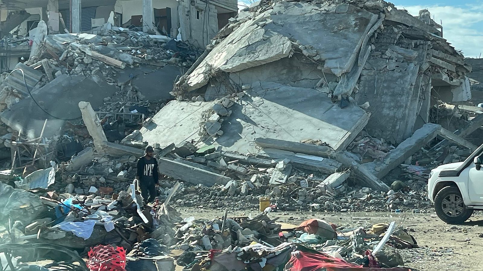 Rubble of collapsed buildings, tiny figure among debris, Gaza Strip