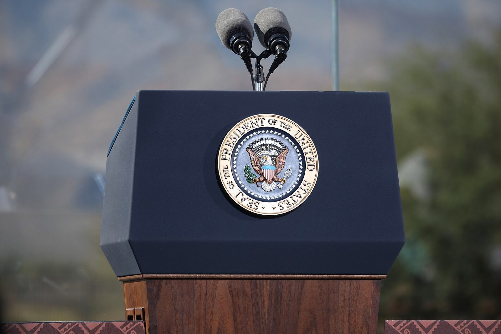 Presidential podium with seal, mountains blurred in background, close-up