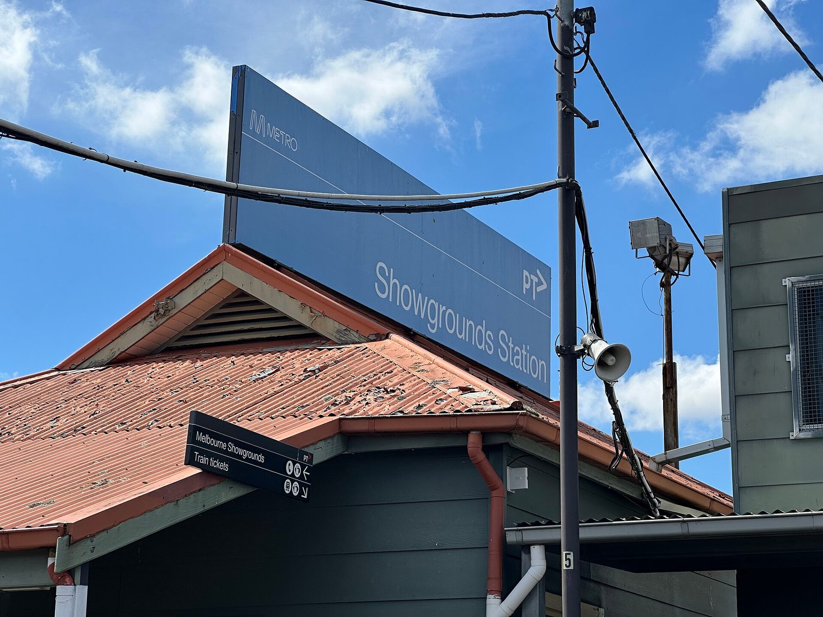 large sign reading 'Showgrounds Station' above station roof, Melbourne Showgrounds
