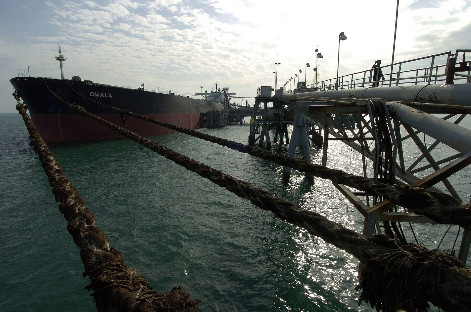 oil tanker tied to a loading jetty, heavy mooring ropes in foreground, Persian Gulf