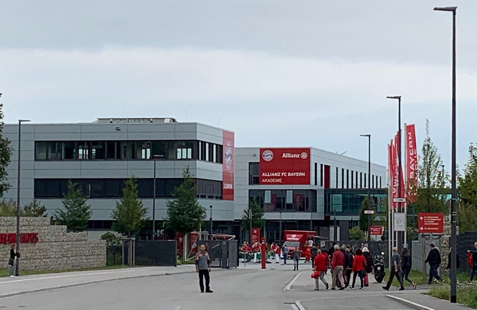 Entrance to Allianz FC Bayern Akademie, people walking toward building