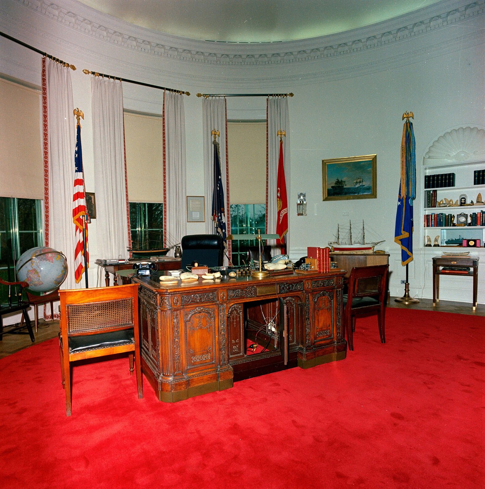 Large formal office interior, ornate desk on red carpet, empty, White House