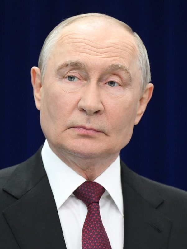 Close-up portrait of man in suit, dark blue background