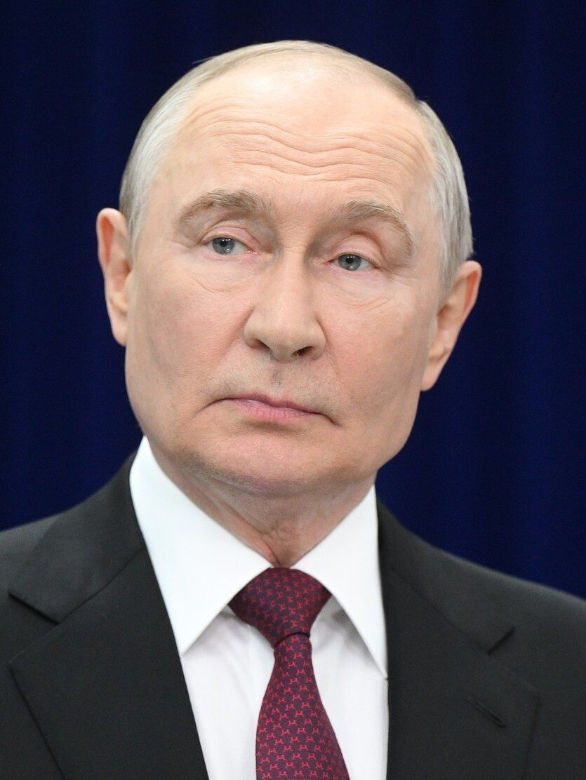 Close-up portrait of a man in a suit, dark blue background