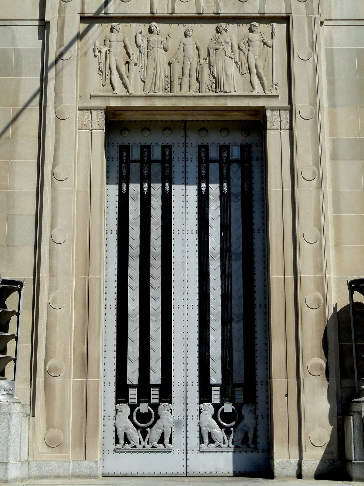 ornate stone entrance with sculpted relief above tall metal doors