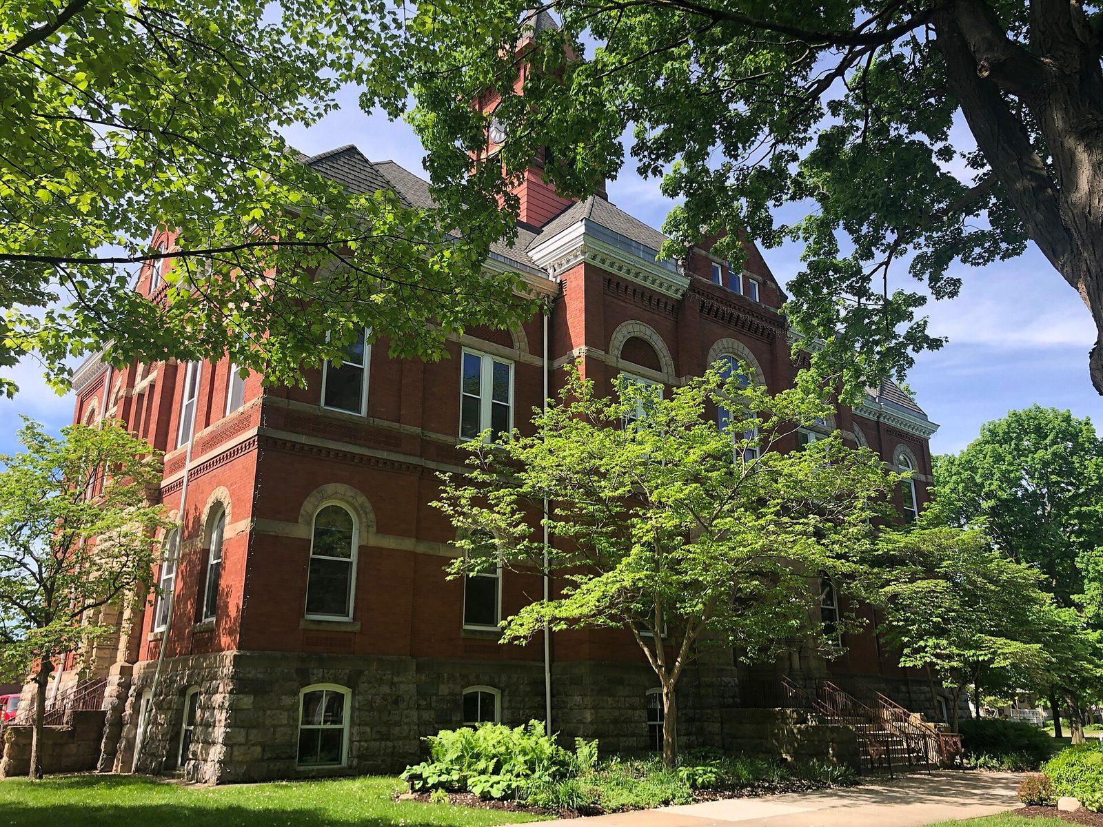 red brick courthouse building partly obscured by trees, Hastings