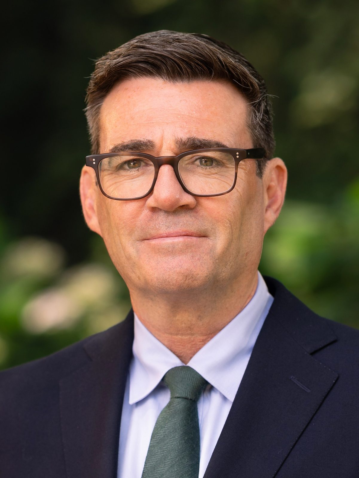 Close head and shoulders portrait of a man wearing glasses and suit