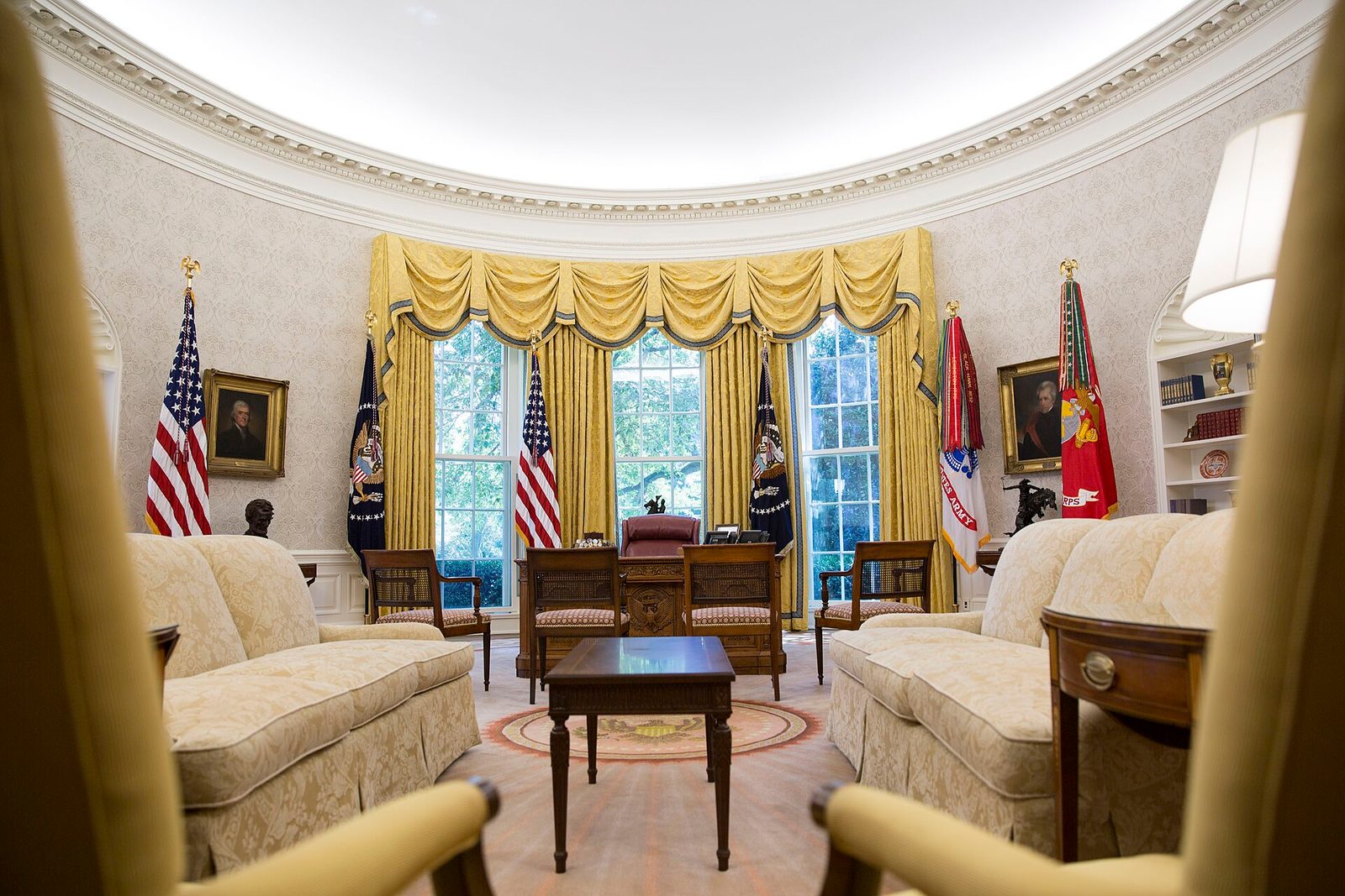 Empty Oval Office, Resolute desk, flags, sofas and golden drapery, White House