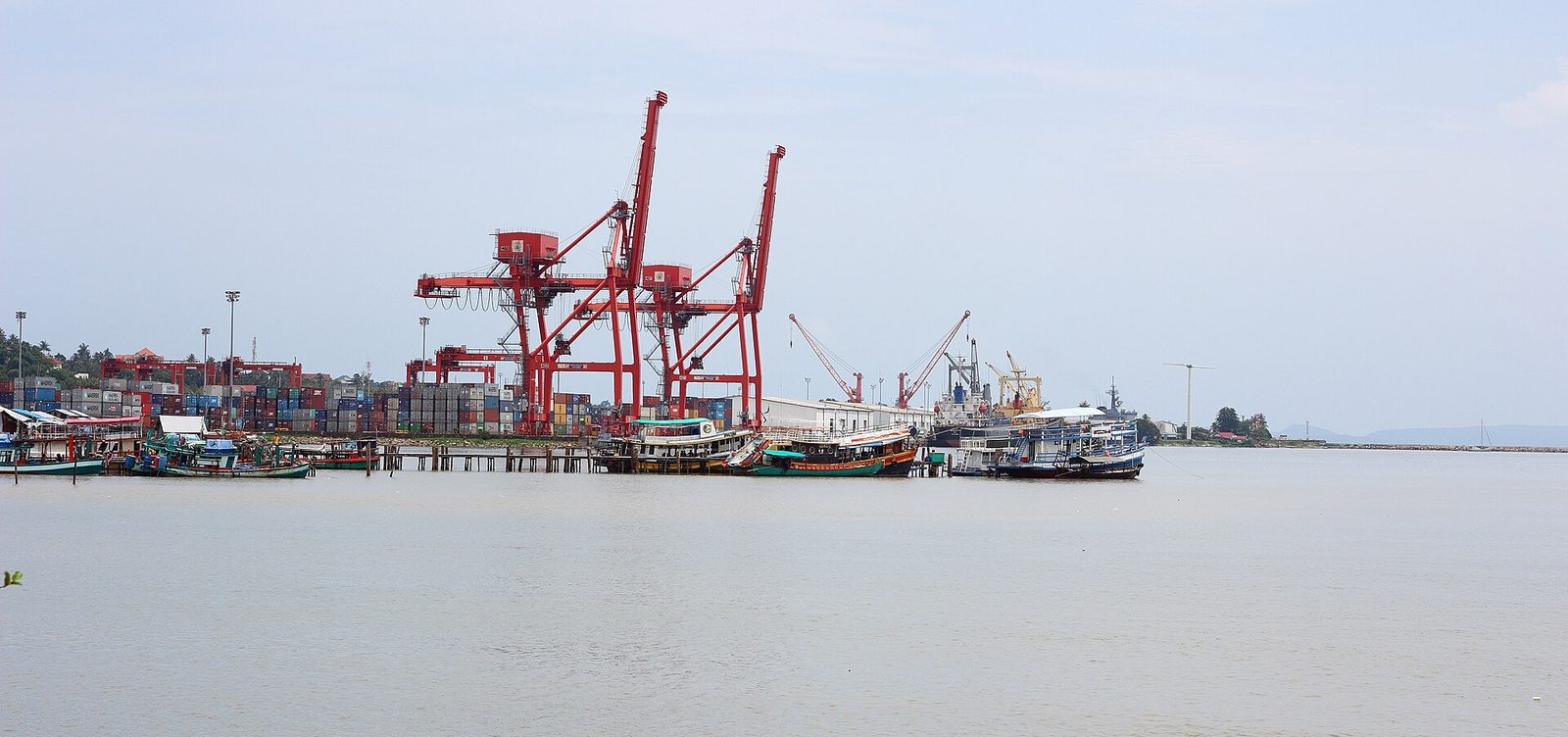 Container cranes, small boats along a distant industrial port waterfront, Sihanoukville