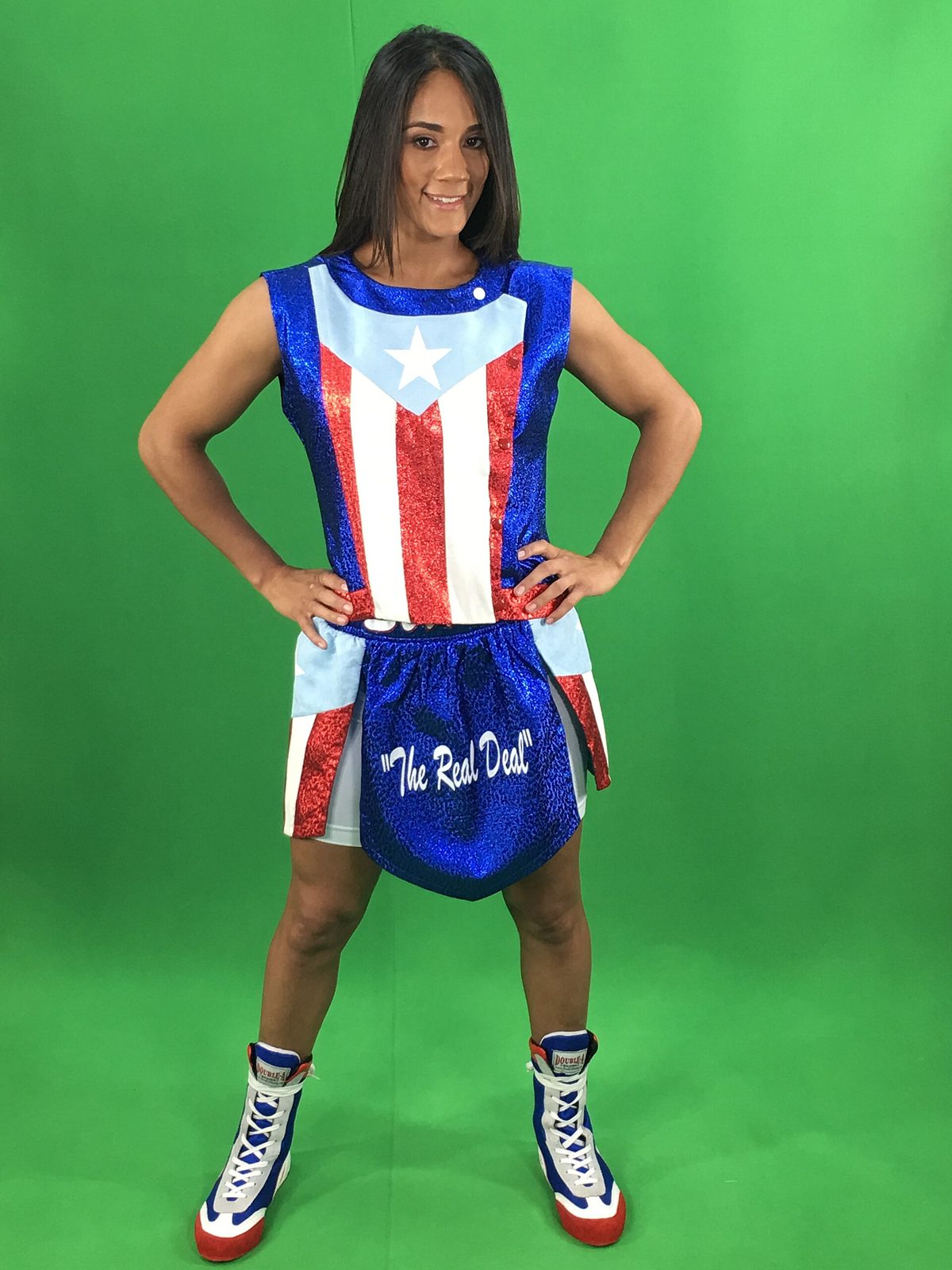 woman in Puerto Rico-style boxing outfit, hands on hips, green background
