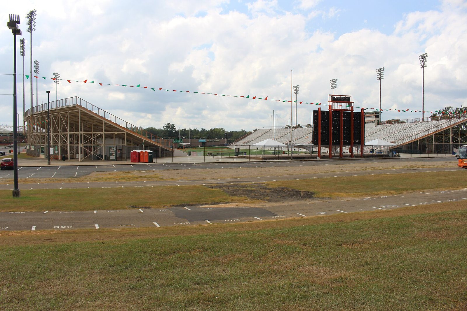 Wide exterior view of stadium, scoreboard, bleachers, empty parking area, Bragg Memorial Stadium