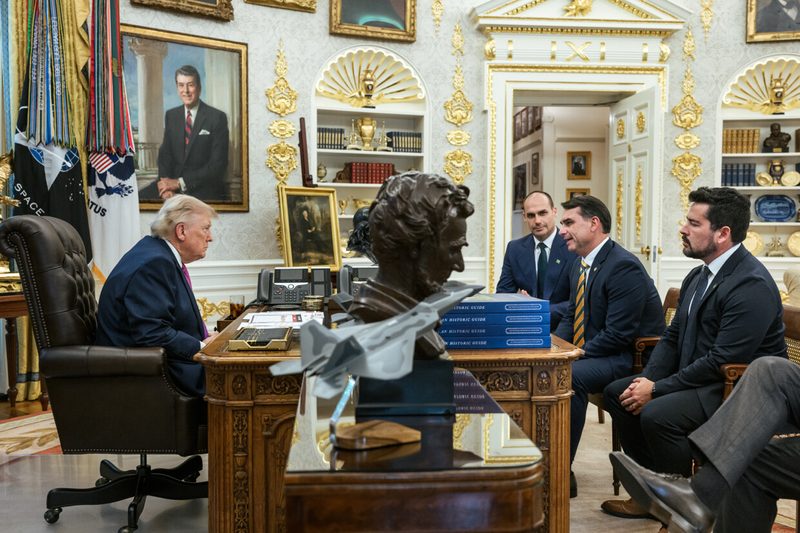 Group of men in suits around a large desk in ornate office