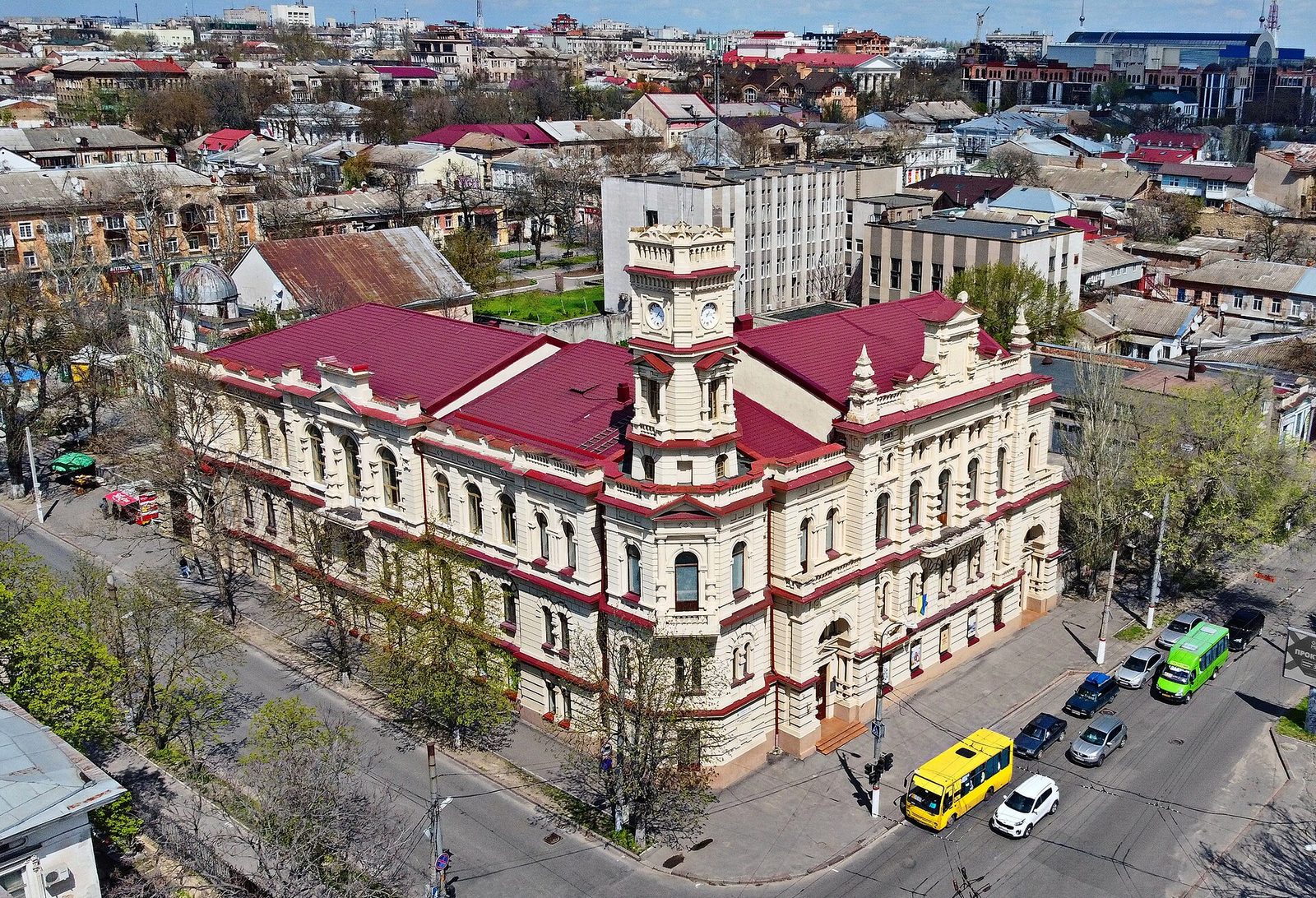 Aerial view of ornate city hall, surrounding streets, buses and cars, Kherson