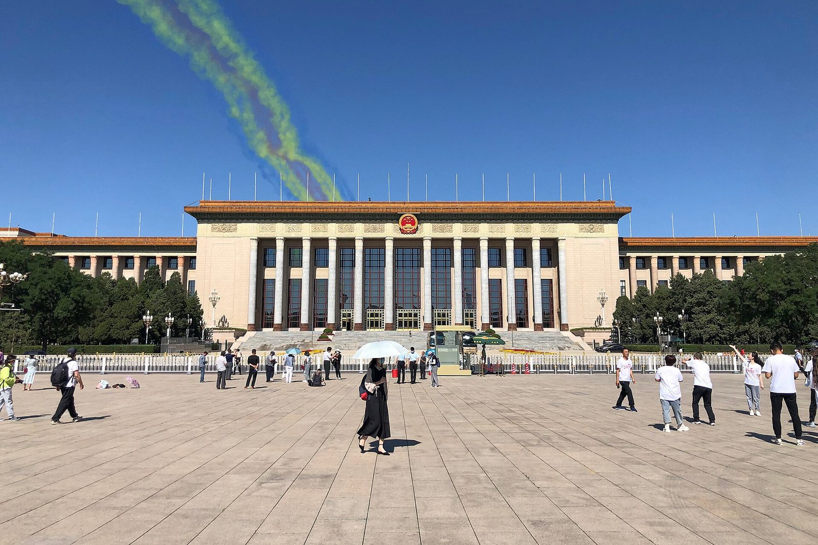 government hall facade, people on square, coloured smoke trails overhead, Beijing