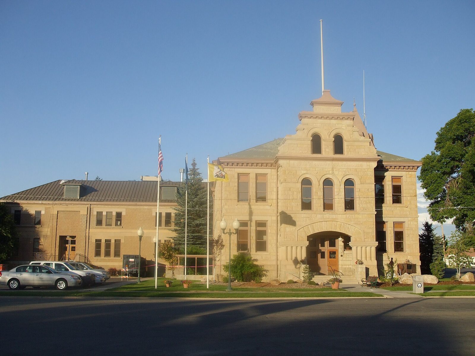 stone courthouse building with flagpoles and parked cars, Summit County