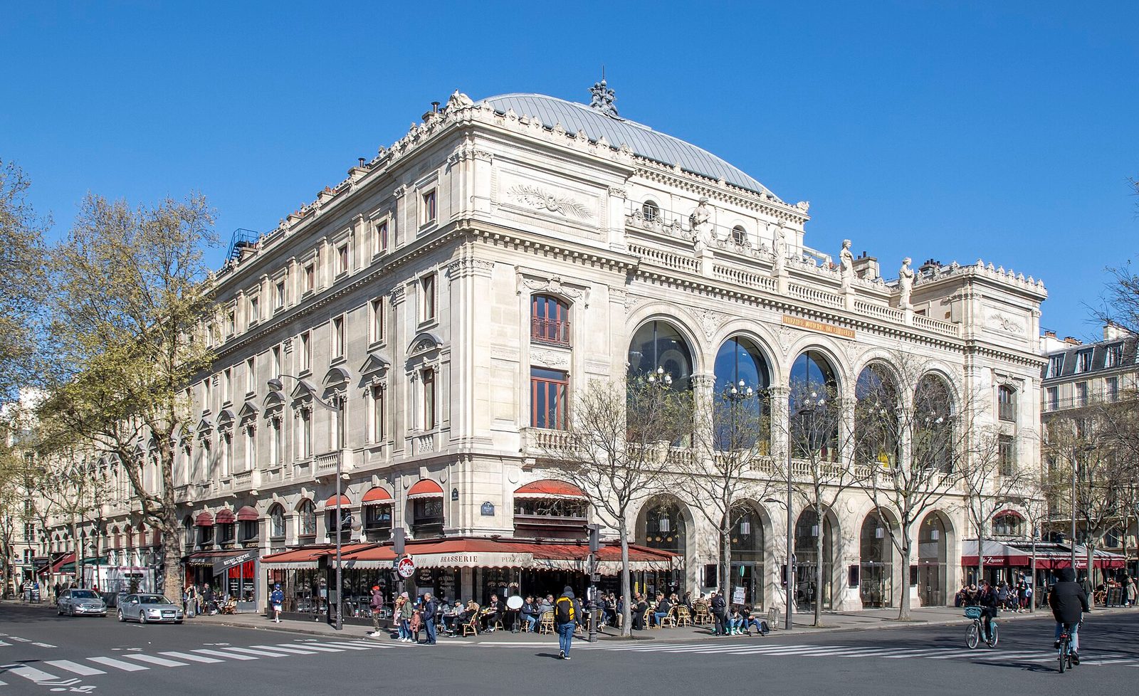 Stone theatre façade with arched windows, outdoor cafés and pedestrians, Theatre du Chatelet
