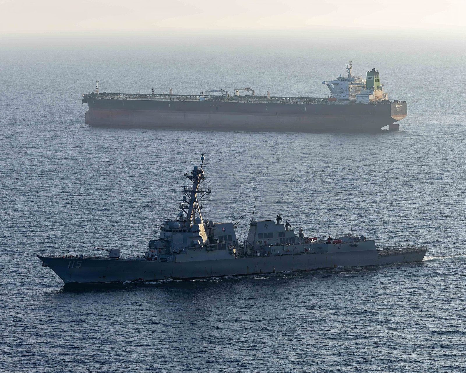 Guided-missile destroyer sailing near a large oil tanker