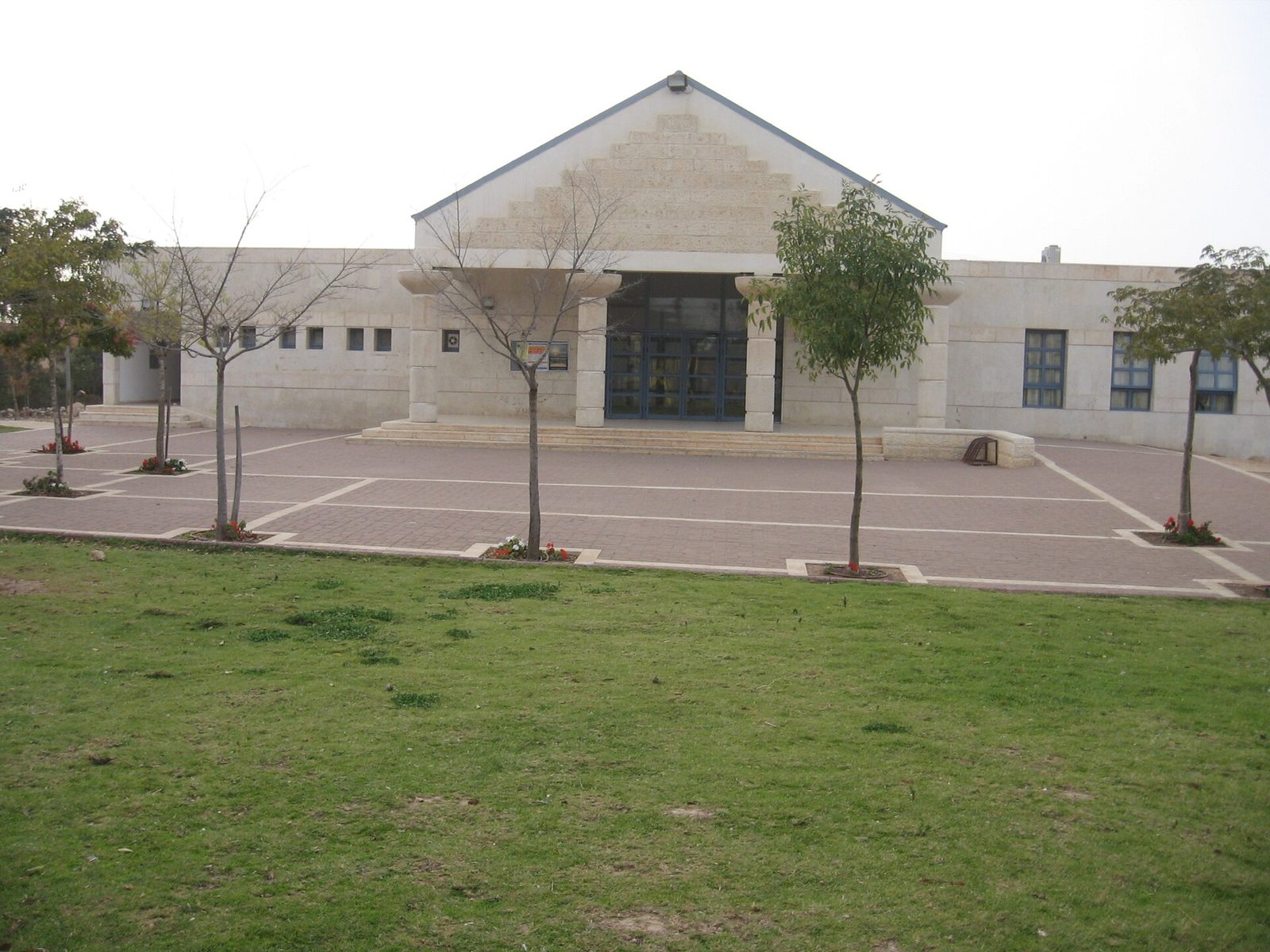 modern building with stepped triangular façade and paved forecourt, Susya