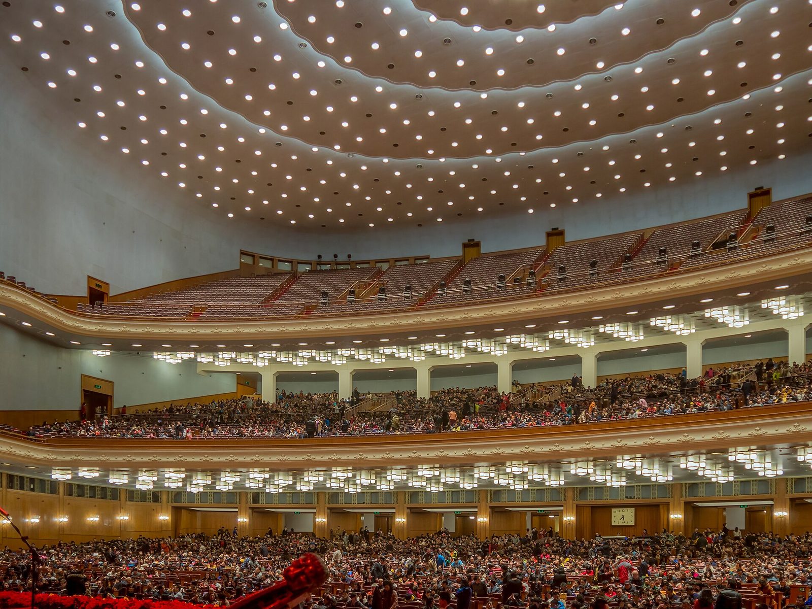 auditorium interior with tiers of seating, crowd filling lower levels, Beijing