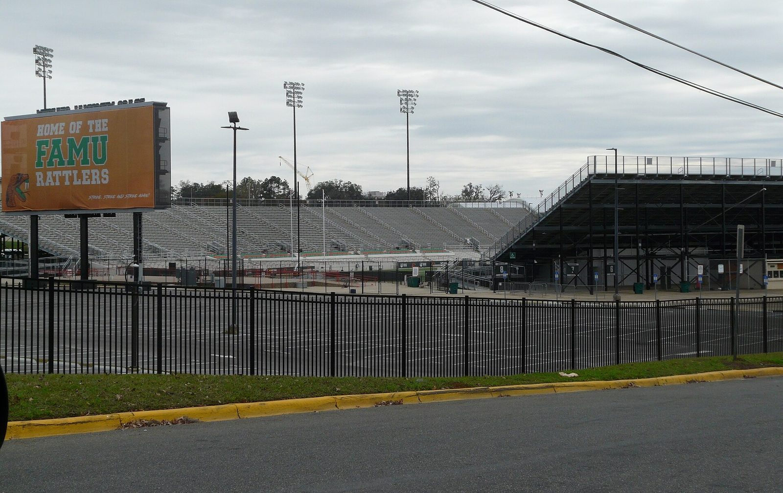 Stadium exterior seen from road, scoreboard and fencing visible, Bragg Memorial Stadium