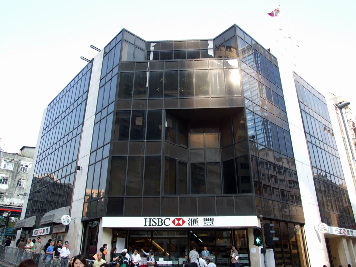 HSBC bank branch frontage, large glass building, people near entrance., Hong Kong