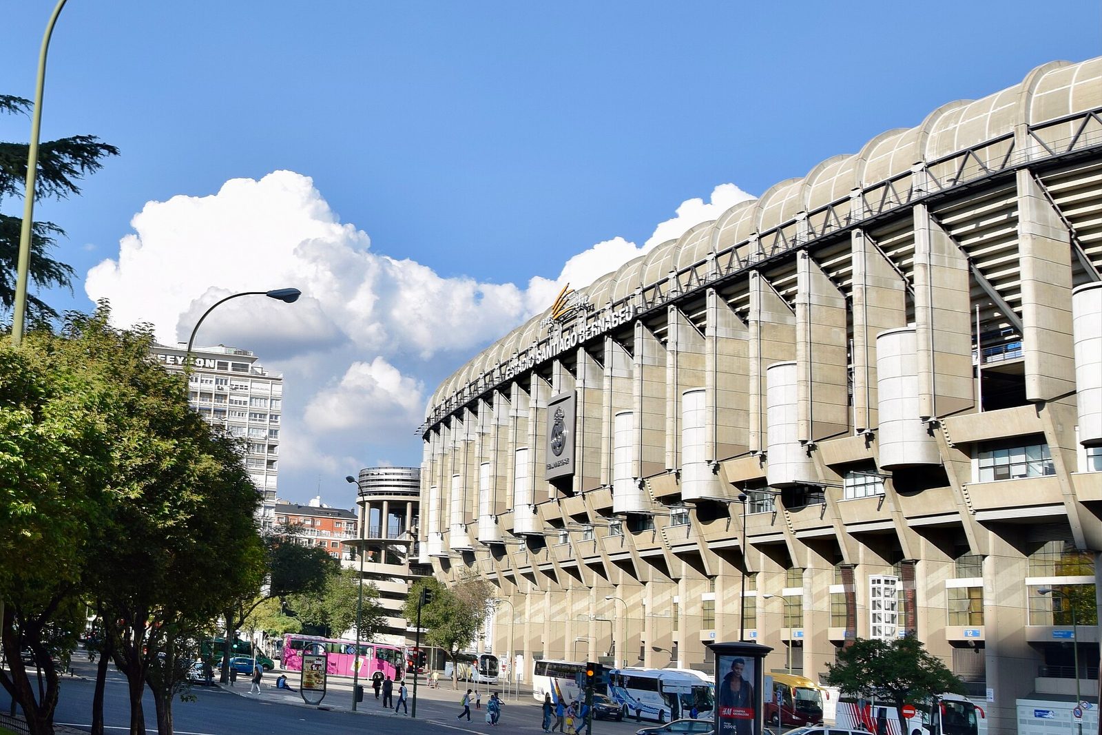 Wide exterior view of Santiago Bernabéu, signage and trees, Santiago Bernabéu