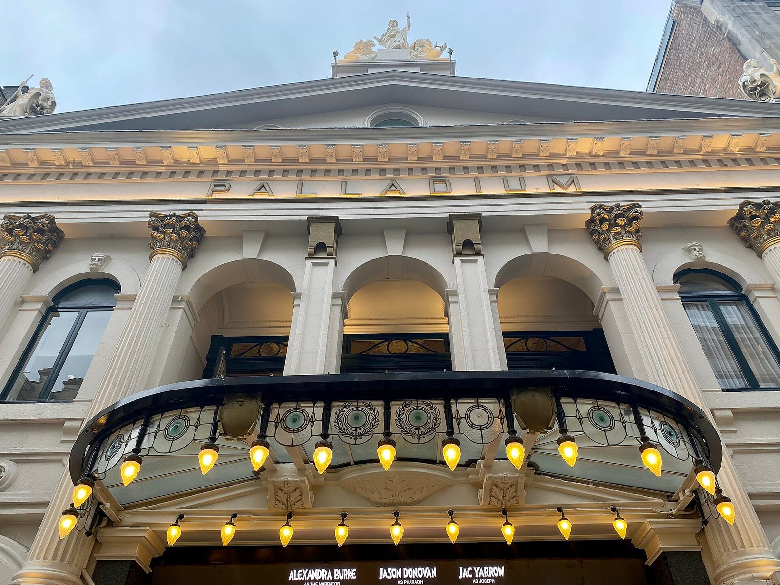 Close view of London Palladium façade, illuminated canopy and 'PALLADIUM' sign, London Palladium