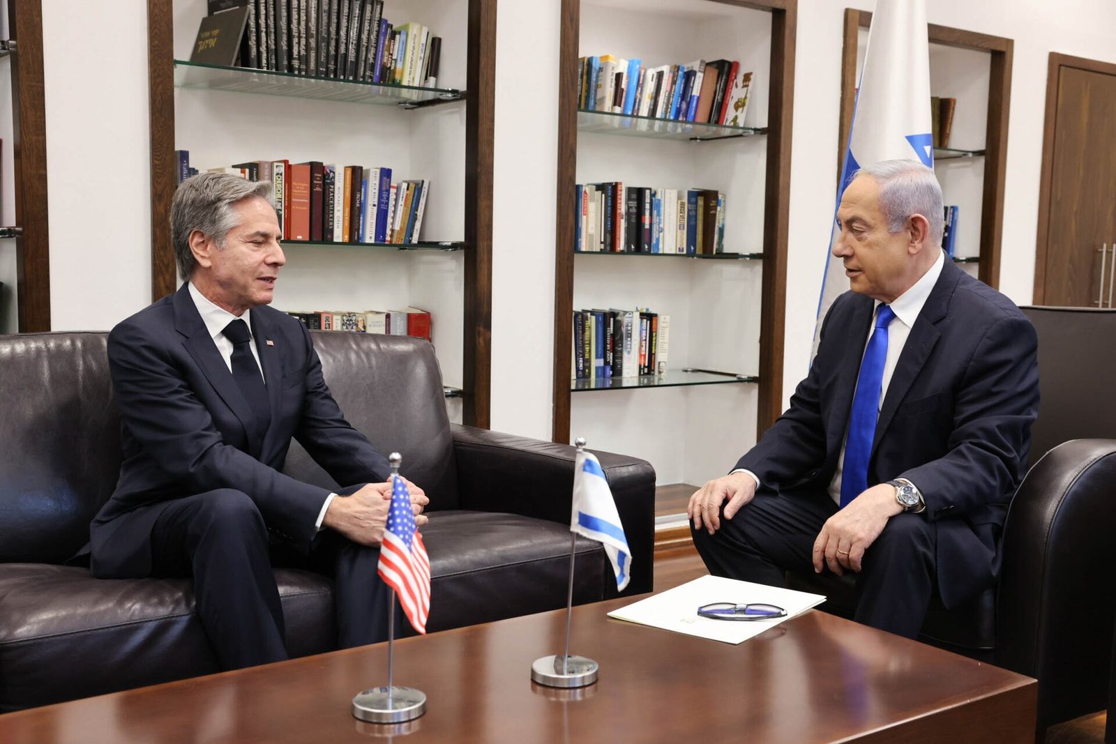 two men seated facing each other, US and Israeli table flags