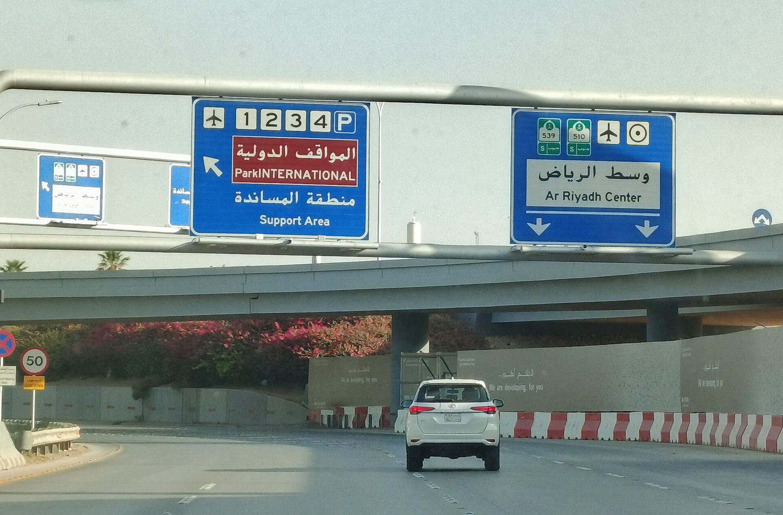 overhead bilingual road signs above approach roadway, King Khalid International Airport