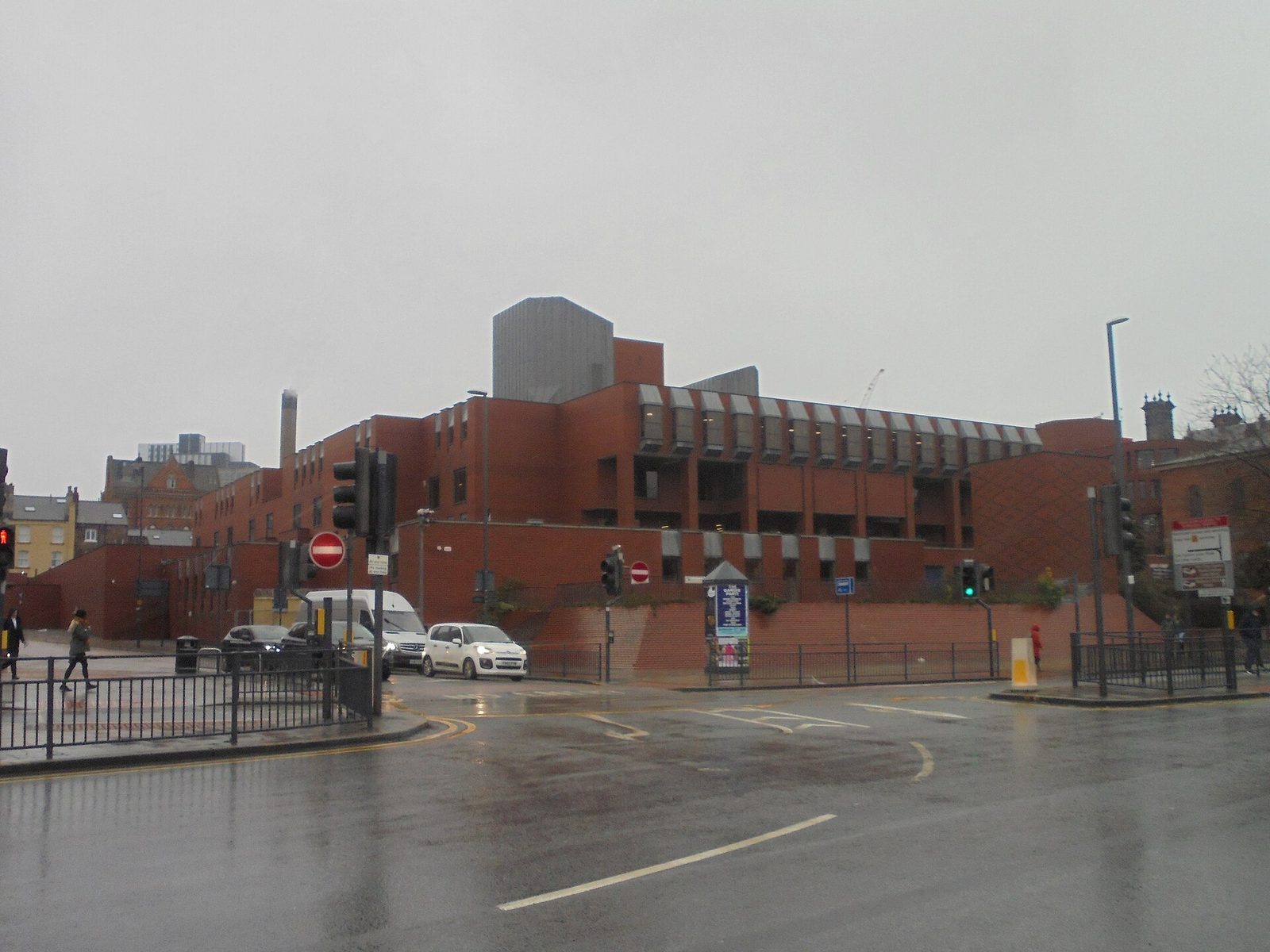 Red-brick combined court centre, forecourt and traffic in view, Leeds