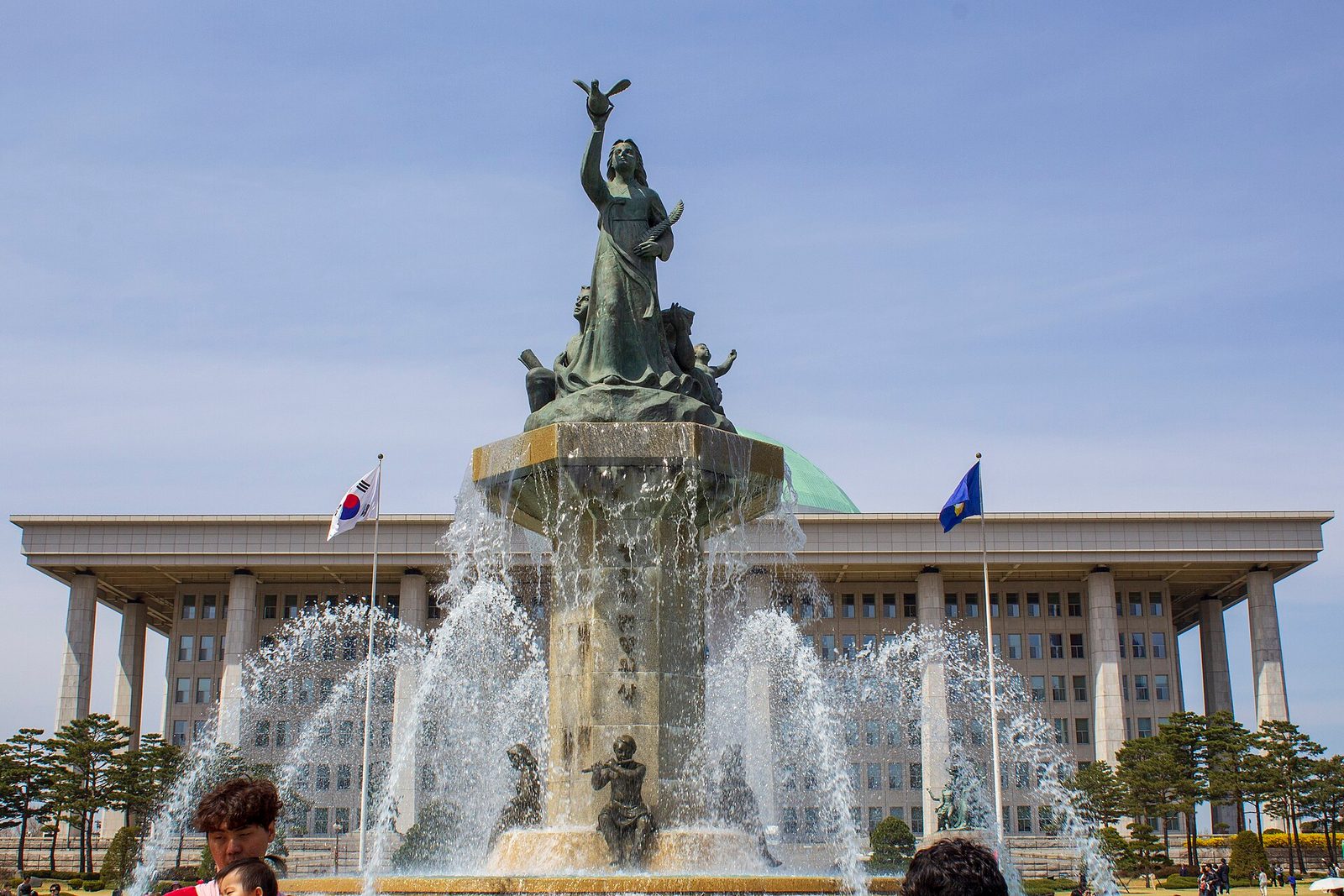 Fountain spraying water in front of a large domed government building, Seoul