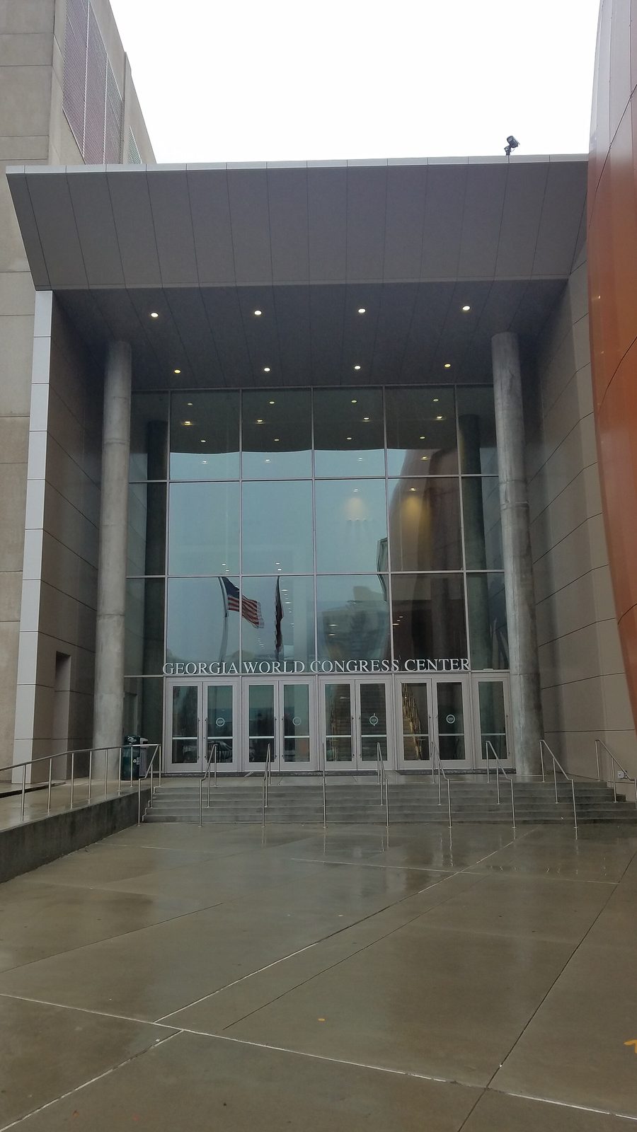 tall glazed entrance with 'Georgia World Congress Center' over doors, steps wet, Atlanta
