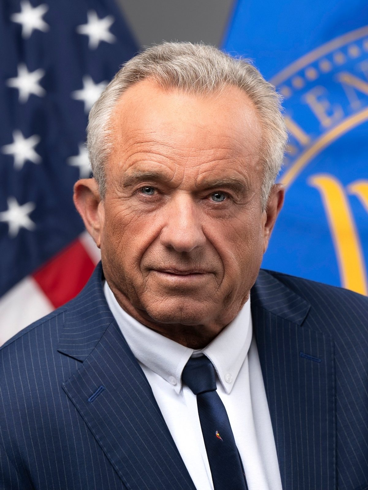 formal head-and-shoulders portrait of a man, US flag background