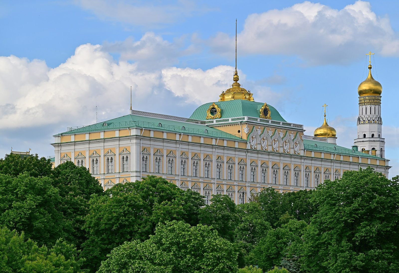 Grand Kremlin Palace and bell tower behind trees, blue sky with clouds, Kremlin Palace