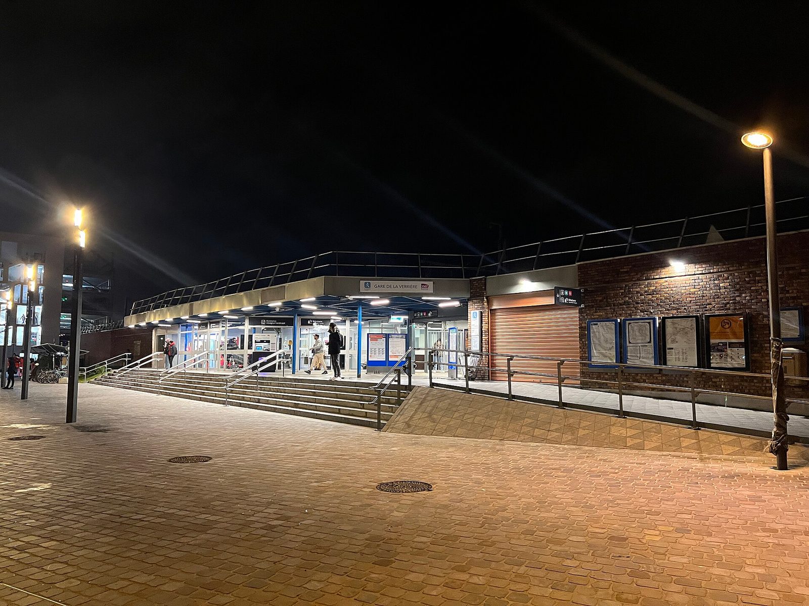 wide exterior view of La Verrière station at night, lit facade
