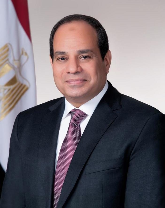 portrait of a man in a suit, flag partly visible