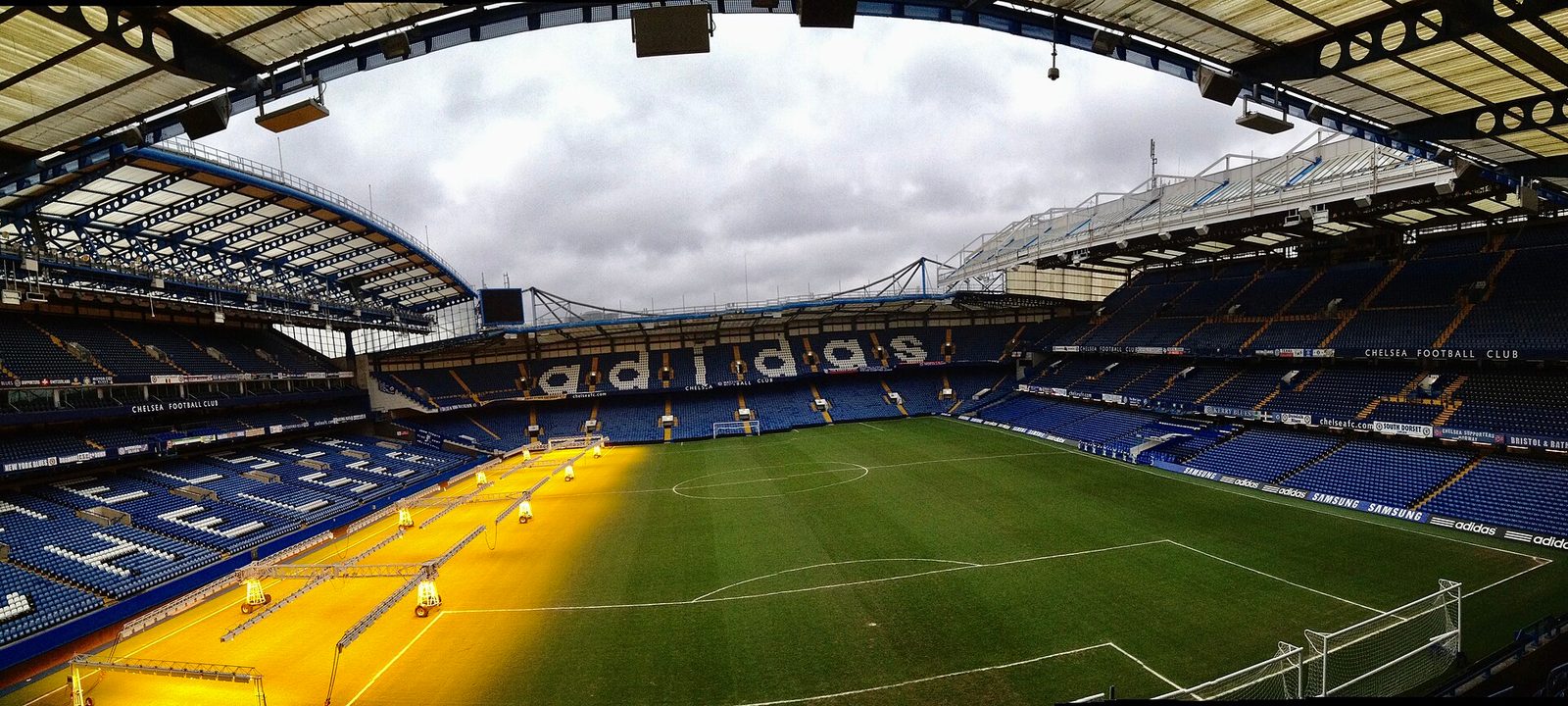 Empty football stadium pitch, stands, grow lights on the turf, Stamford Bridge