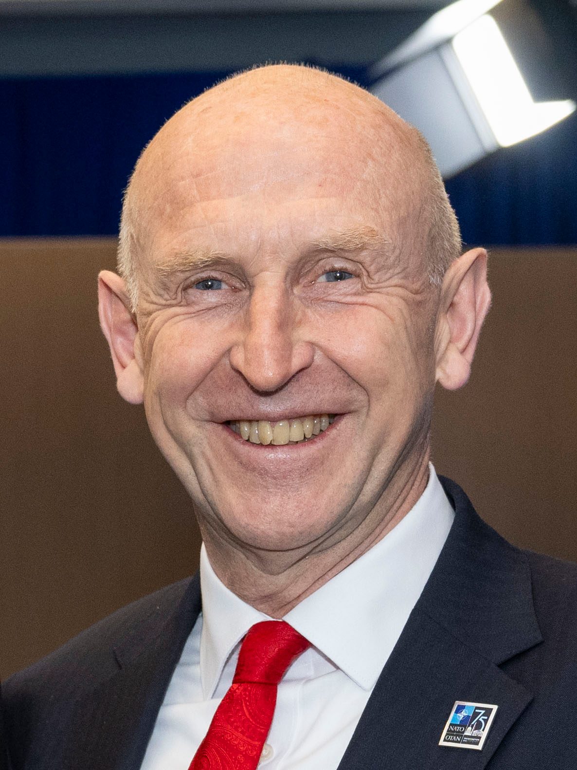 Smiling bald man in suit, white shirt and red tie