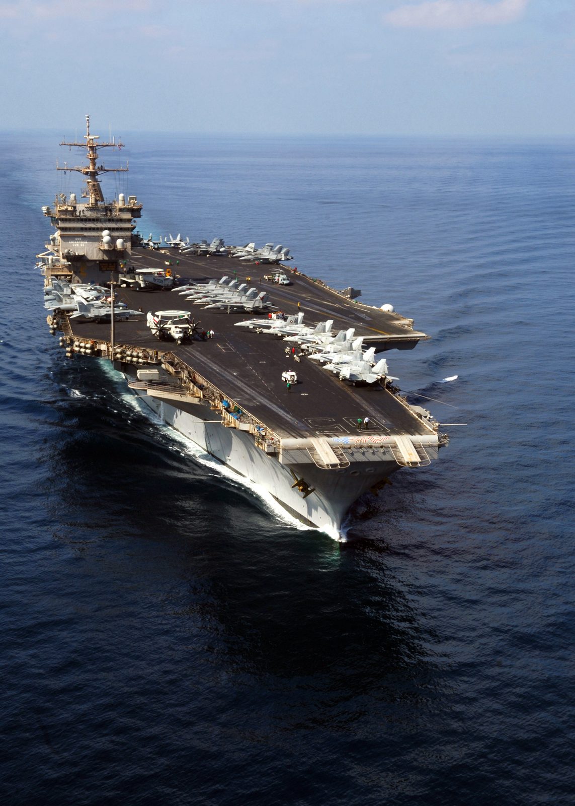 aircraft carrier steaming at sea, aircraft parked on flight deck