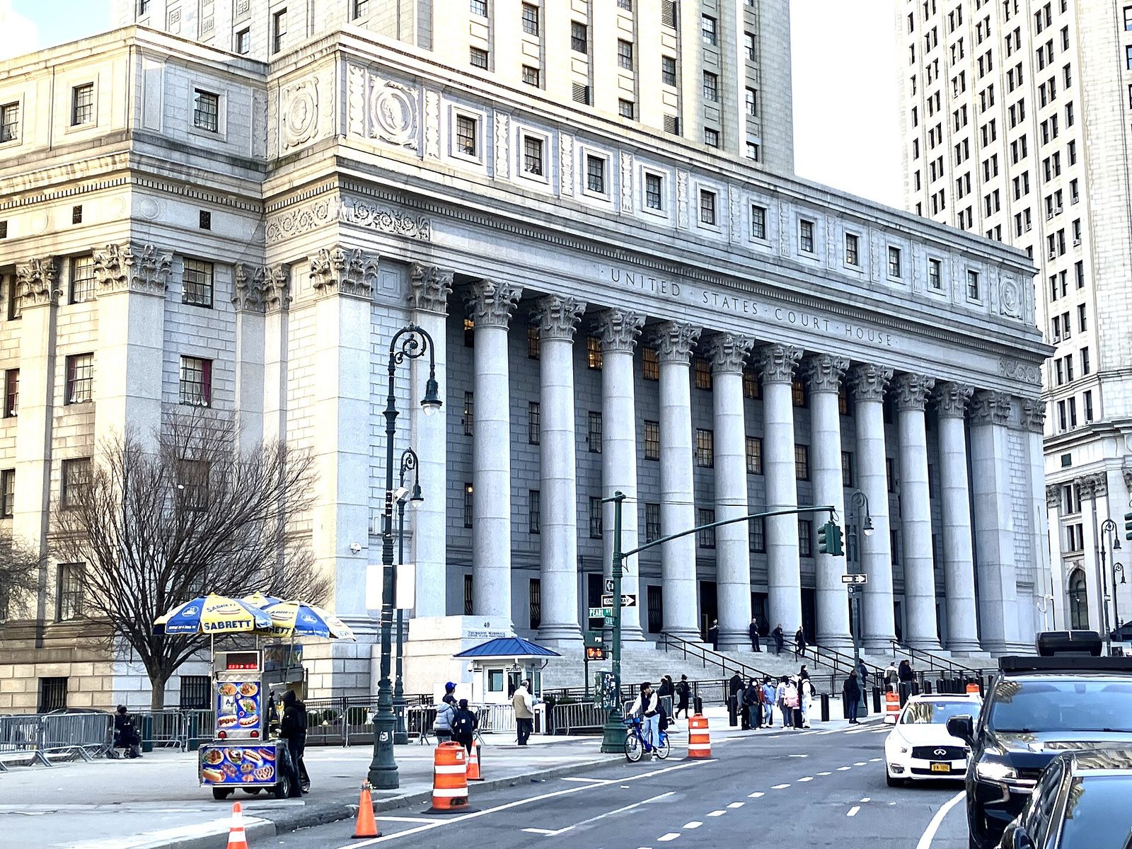 neoclassical courthouse facade with tall columns, steps and people outside
