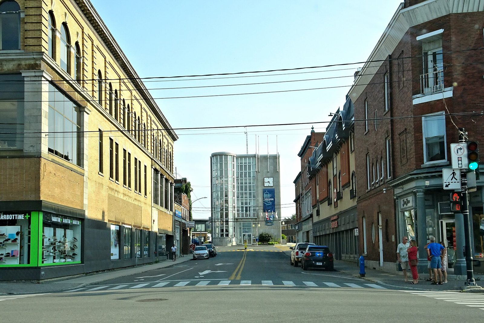 Street view down to municipal building, cars and pedestrians